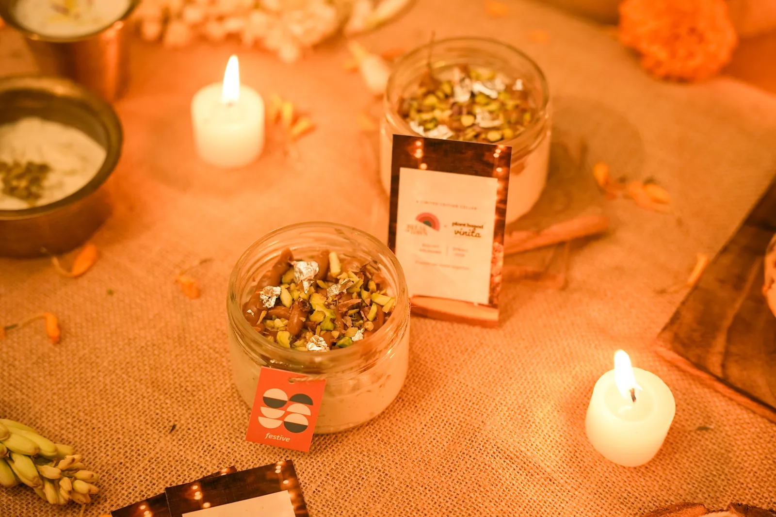 The Biscoff kalakand jar on the Diwali table beside its collab card, a candle in front