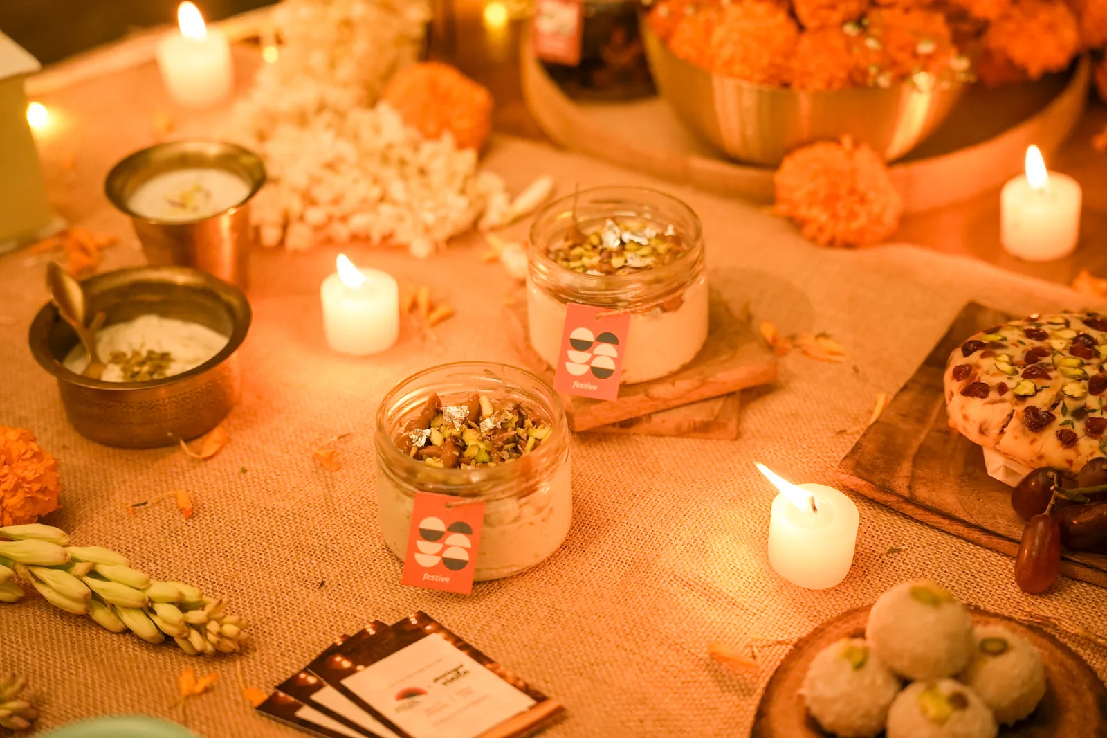 Two jars of Biscoff kalakand on the Diwali table with tea lights and coconut sandesh