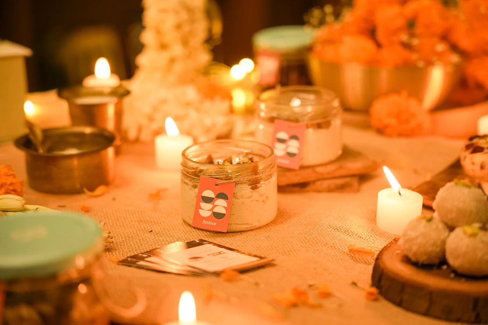 A jar of Biscoff kalakand among marigolds and candles