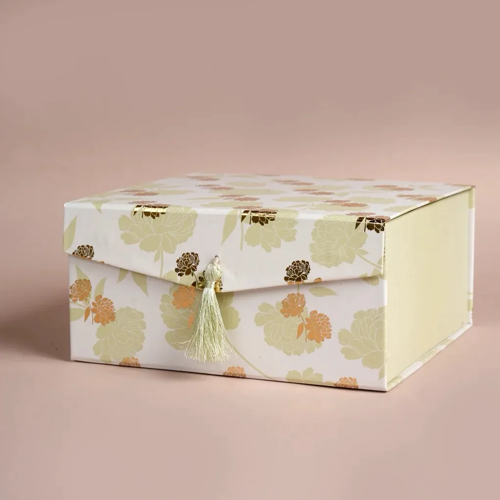 A floral paper gift box with a tassel