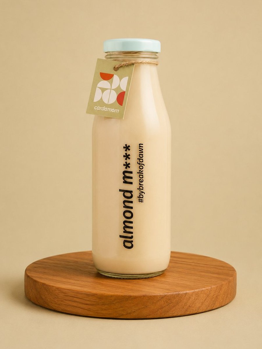A glass bottle of Break of Dawn cardamom almond milk, made fresh in Mumbai