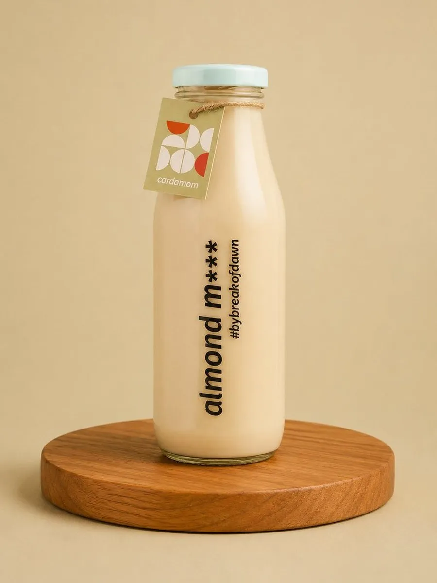 A glass bottle of Break of Dawn cardamom almond milk, made fresh in Mumbai
