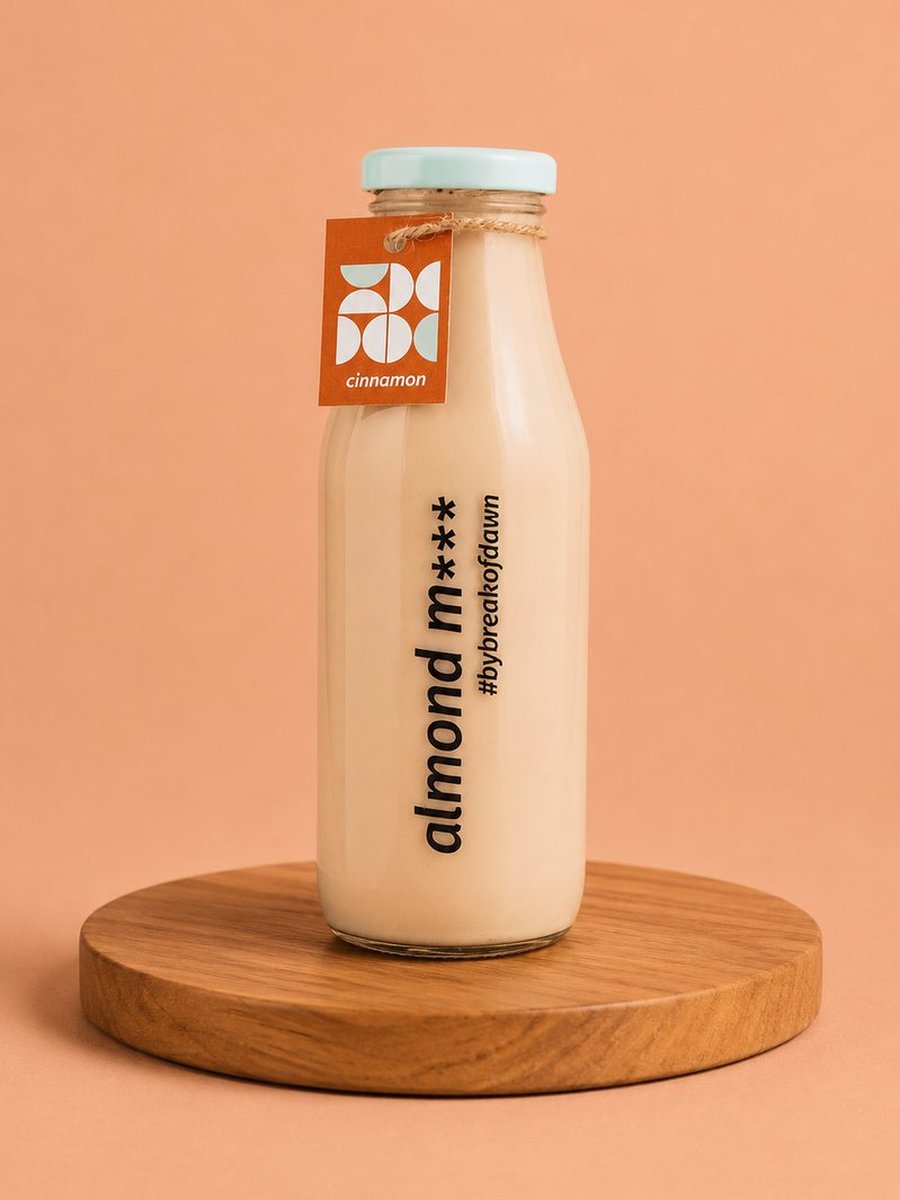 A glass bottle of Break of Dawn cinnamon almond milk, made fresh in Mumbai