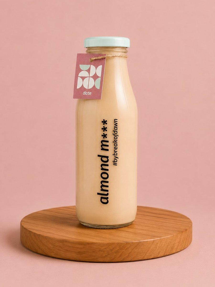 A glass bottle of Break of Dawn dates almond milk, made fresh in Mumbai