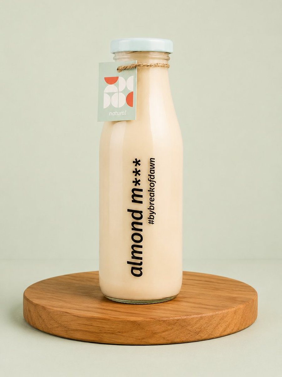 A glass bottle of Break of Dawn natural almond milk, made fresh in Mumbai
