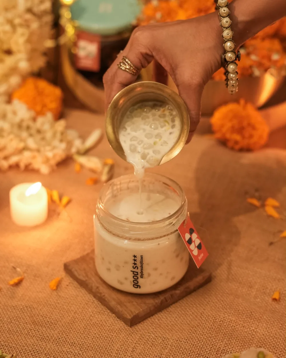 Coconut sago kheer being poured from a brass cup into a Break of Dawn jar