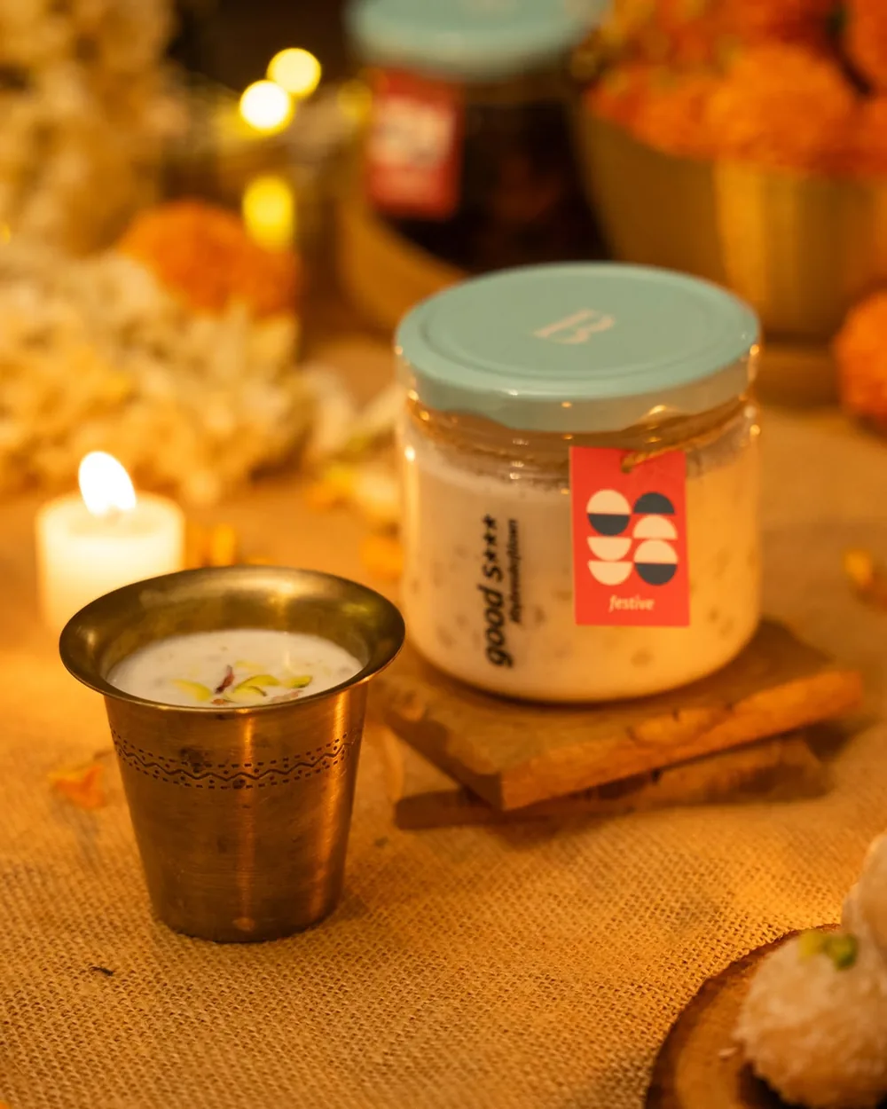 A jar of Break of Dawn coconut sago kheer on a festive table with marigolds and candles