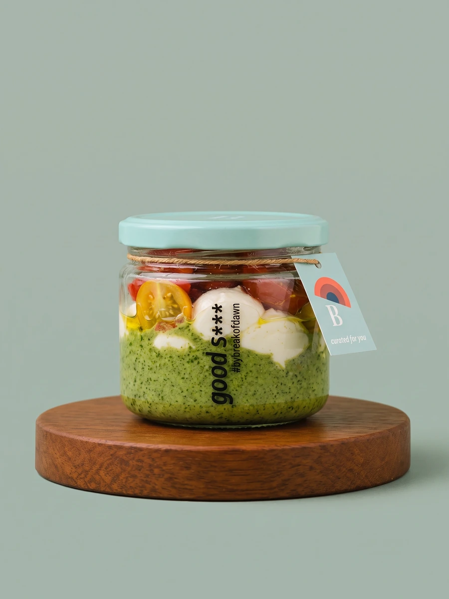 A jar of Break of Dawn pesto burrata, plant-based burrata on basil pesto with cherry tomatoes